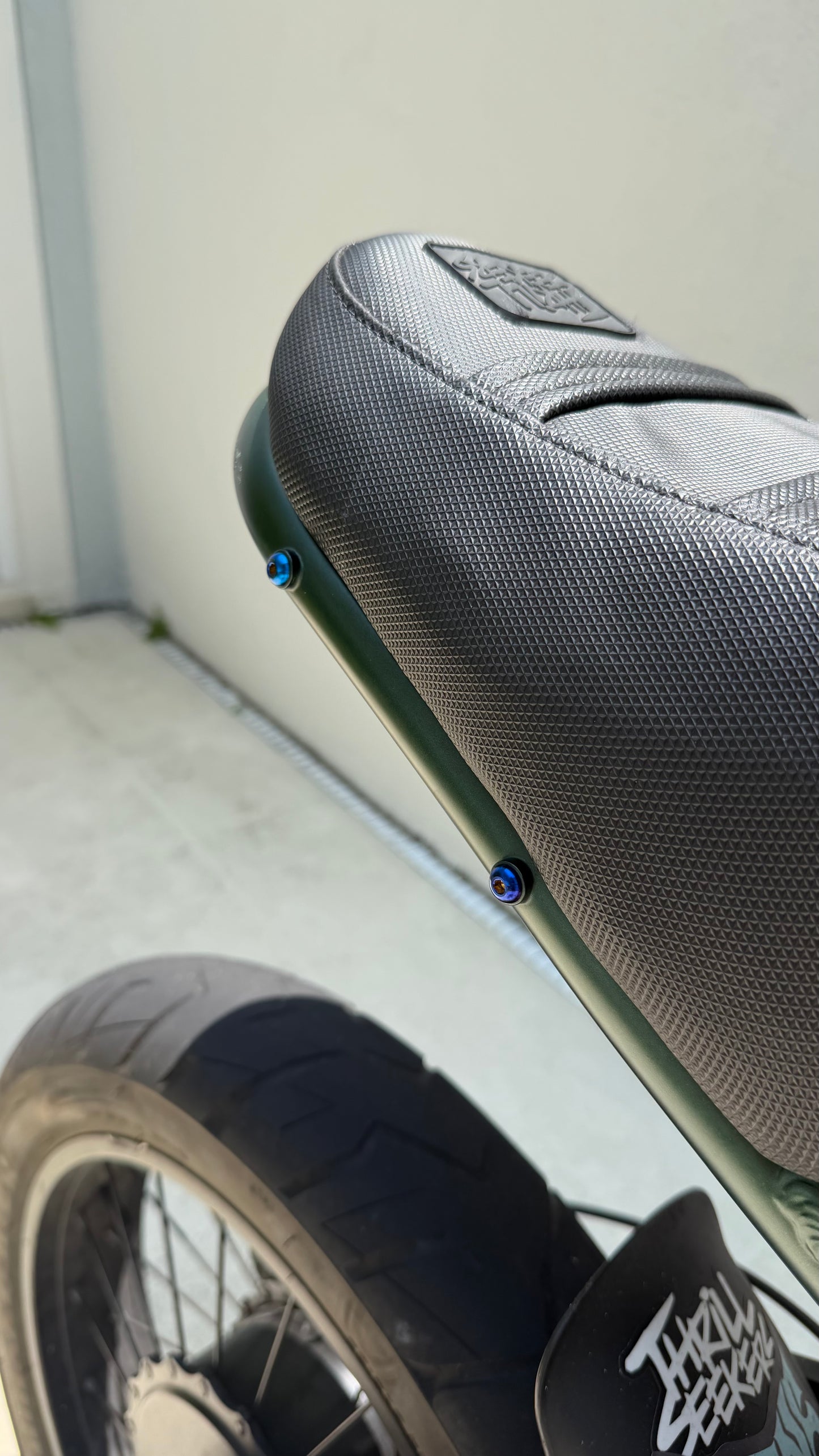 Close-up of a motorcycle seat with visible branding on a plain background