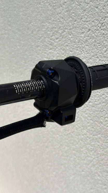 Close-up of a black motorcycle handlebar on a textured gray background