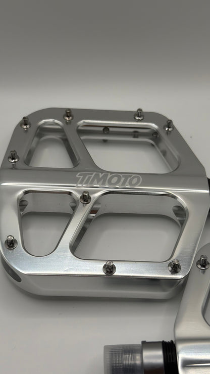 Metallic foot peg with 'TIMOTO' branding on a gray background