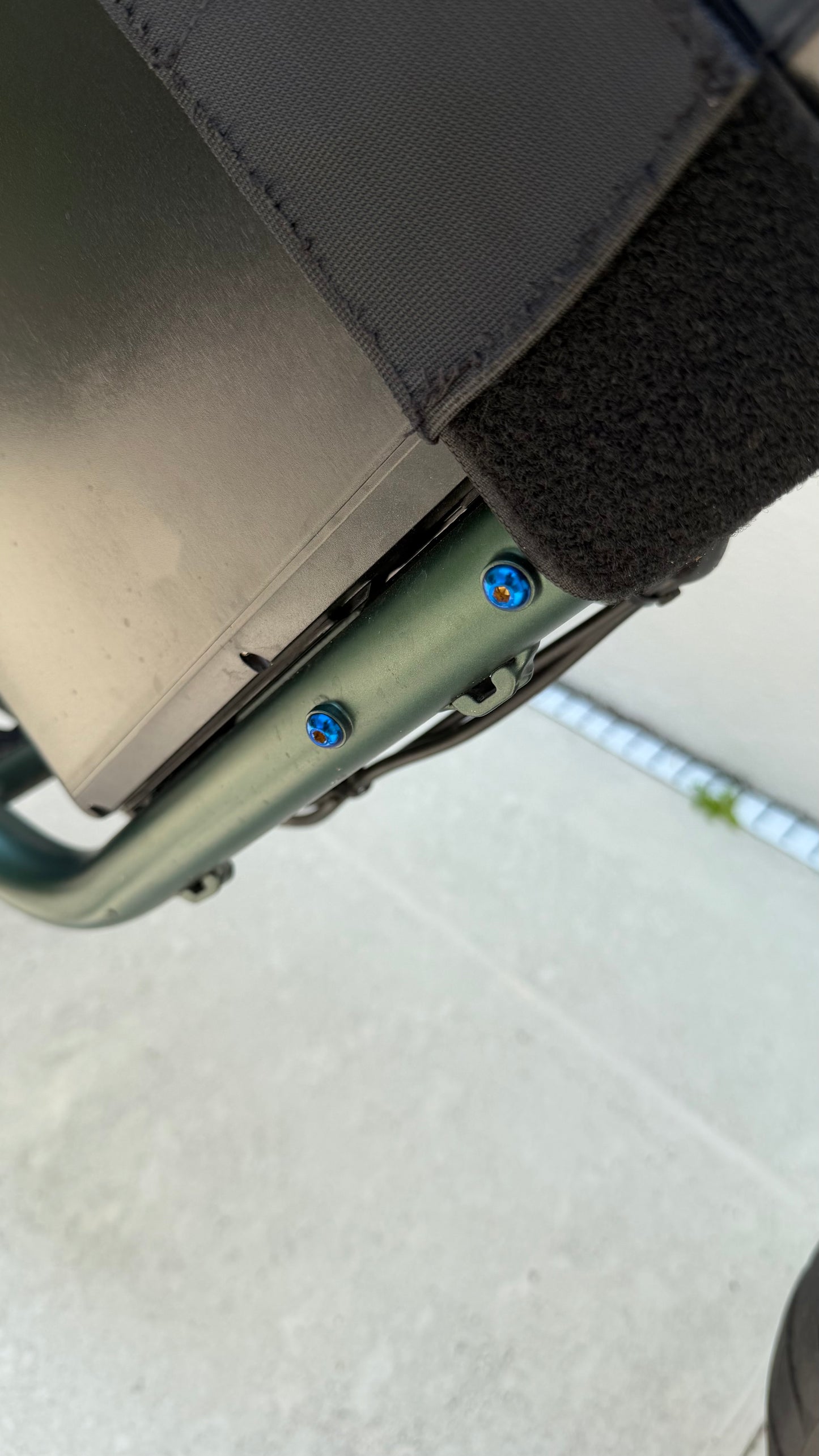 Close-up of a bike frame bolts with visible screws on a blurred background