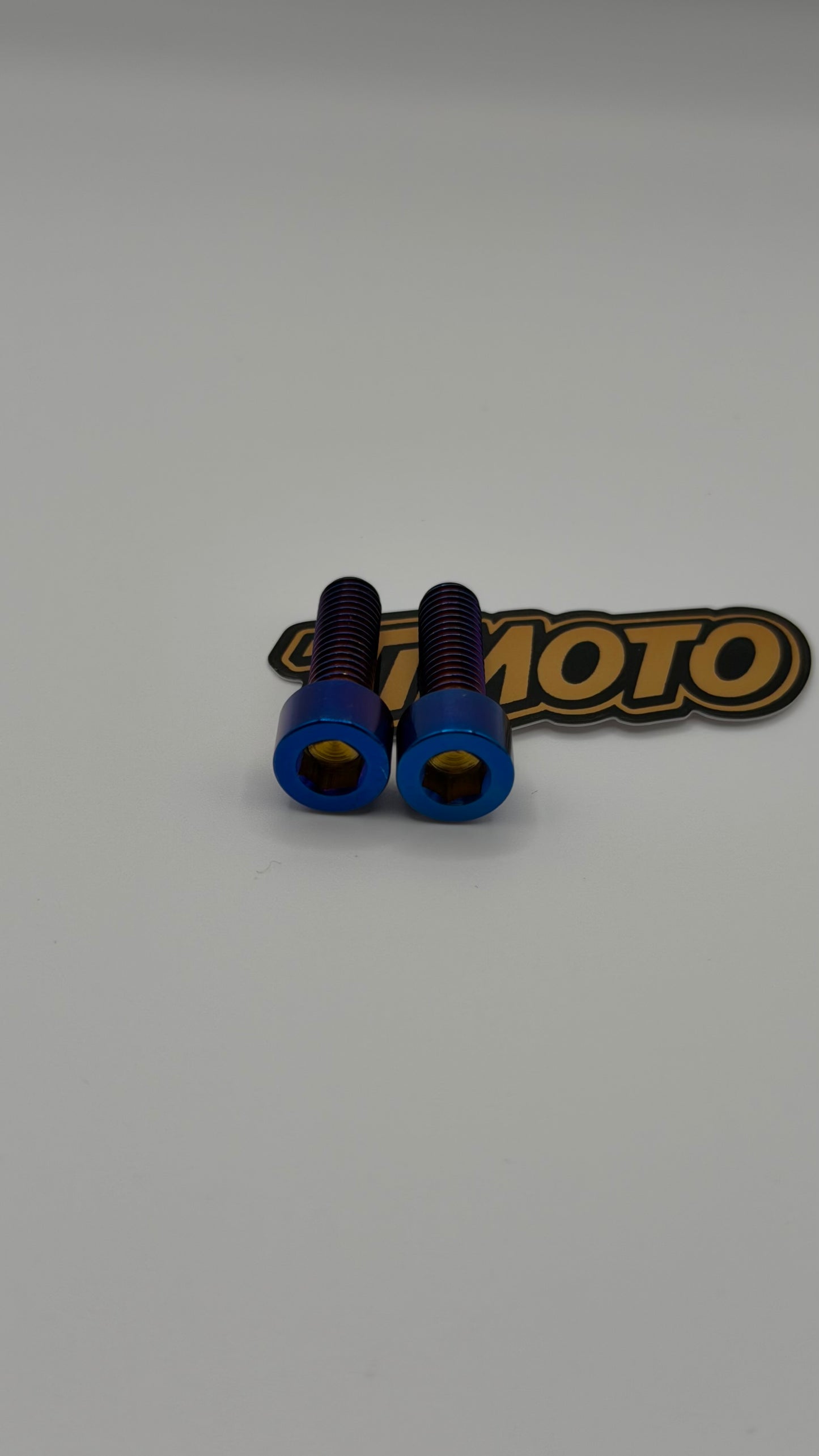 Two blue screws on a white background with a 'timoto' branded sticker.