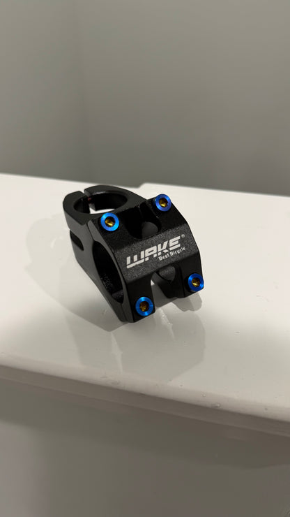 Black bike stem with blue bolts on a white surface