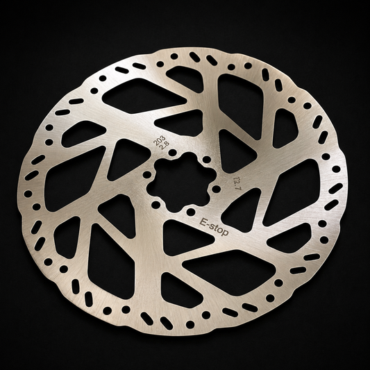 Metallic brake disc with E-stop marking on a black background